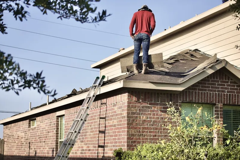 Professional roofer working on a residential roof in Allston